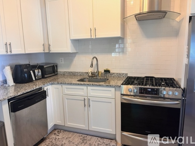 A kitchen with white cabinets and a black stove top.
