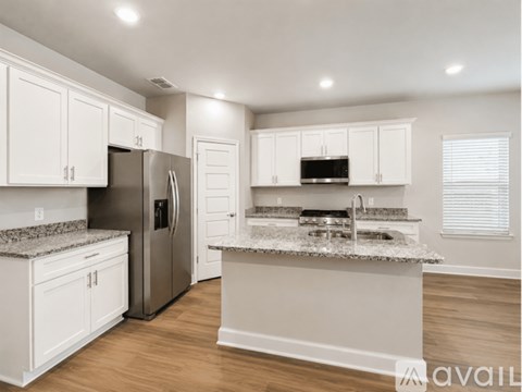 A kitchen with white cabinets and a granite countertop.