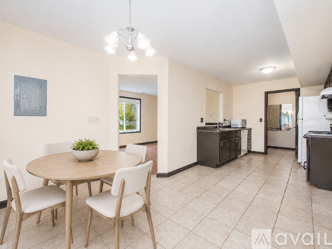 A dining area with a round table and chairs.