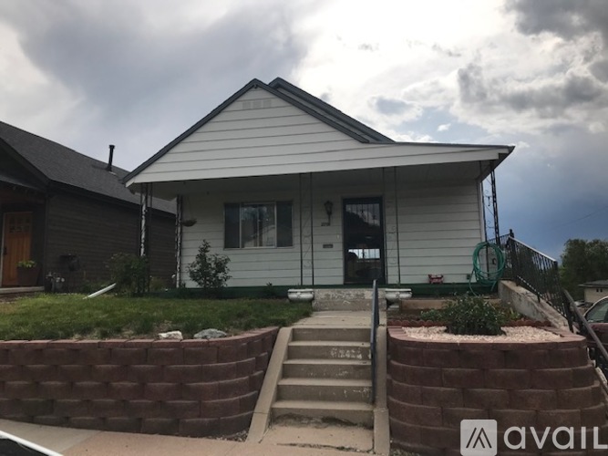 A house with a white siding and a black door is for sale.