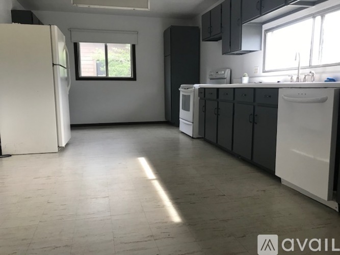 A kitchen with white appliances and black cabinets.