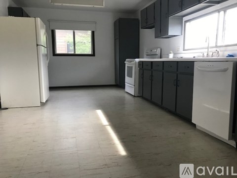 A kitchen with white appliances and black cabinets.