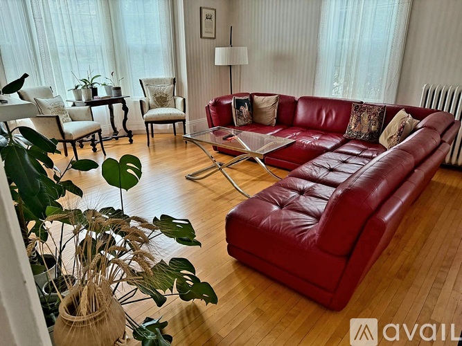 A living room with a red leather couch and a glass coffee table.