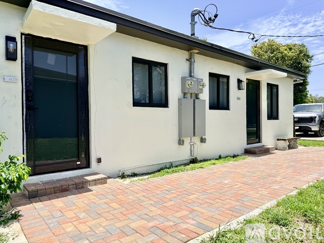 A house with a brick walkway in front.