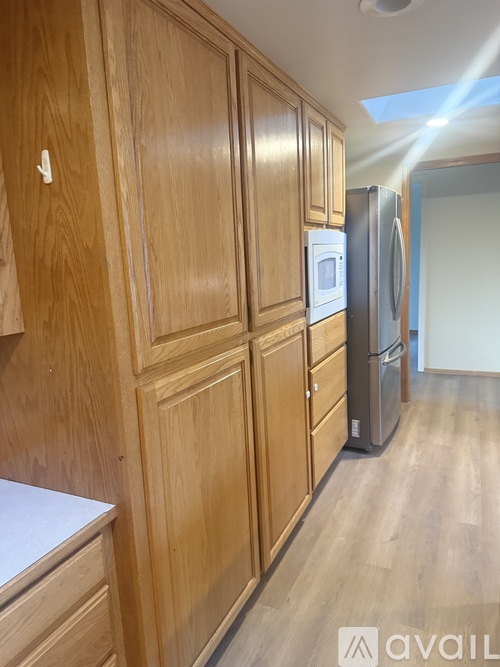 A kitchen with wooden cabinets and a refrigerator.