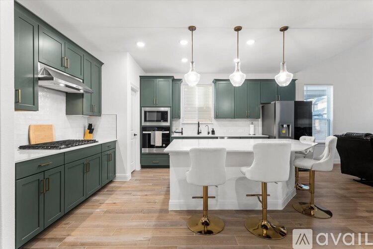 A kitchen with green cabinets and white countertops.