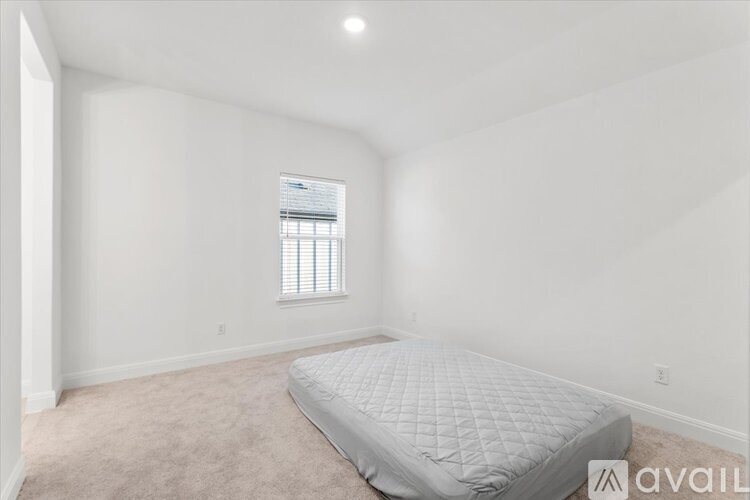 A bedroom with a bed and a window.