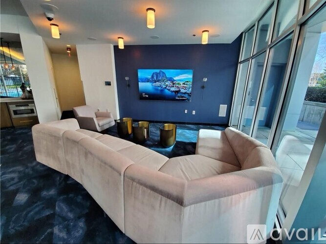 A living room with a large couch and a television on the wall.