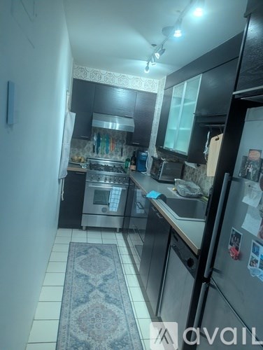 A kitchen with a refrigerator, sink, and stove.