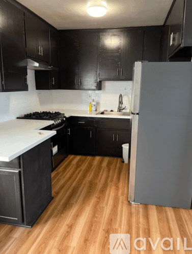A kitchen with black cabinets and a white countertop.