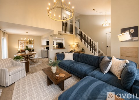 A living room with a blue couch and a striped armchair.
