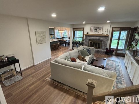 A living room with a couch, a fireplace, and a painting on the wall.