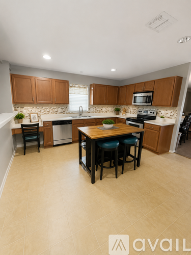 A kitchen with a refrigerator, sink, and a plant on a wooden table.