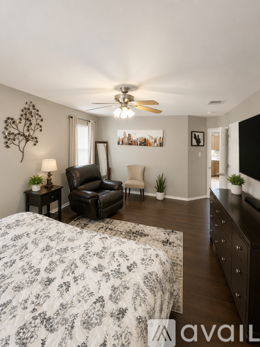 A bedroom with a large bed and a ceiling fan.