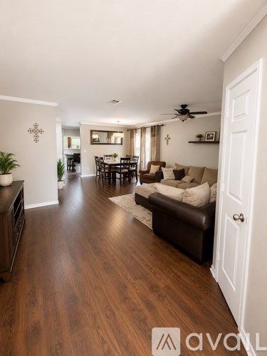A well-lit living room with a dining table and chairs.