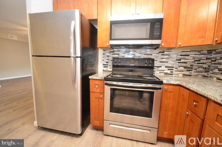 A kitchen with a stainless steel refrigerator, a microwave, and a stove top oven.