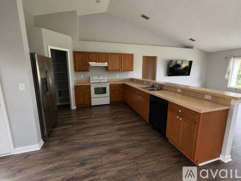 A kitchen with wooden cabinets and a refrigerator.