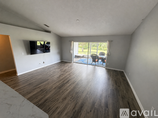 A living room with a flat screen TV mounted on the wall.