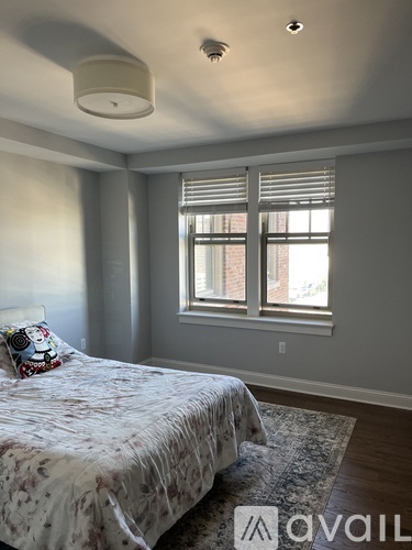 A bedroom with a bed and a window with blinds.