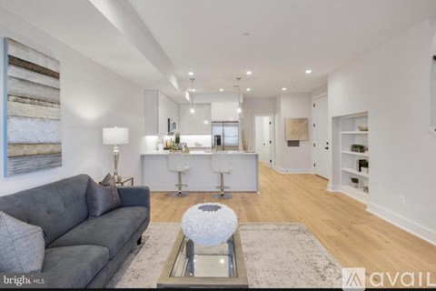 A modern living room with a grey sofa and a glass coffee table.