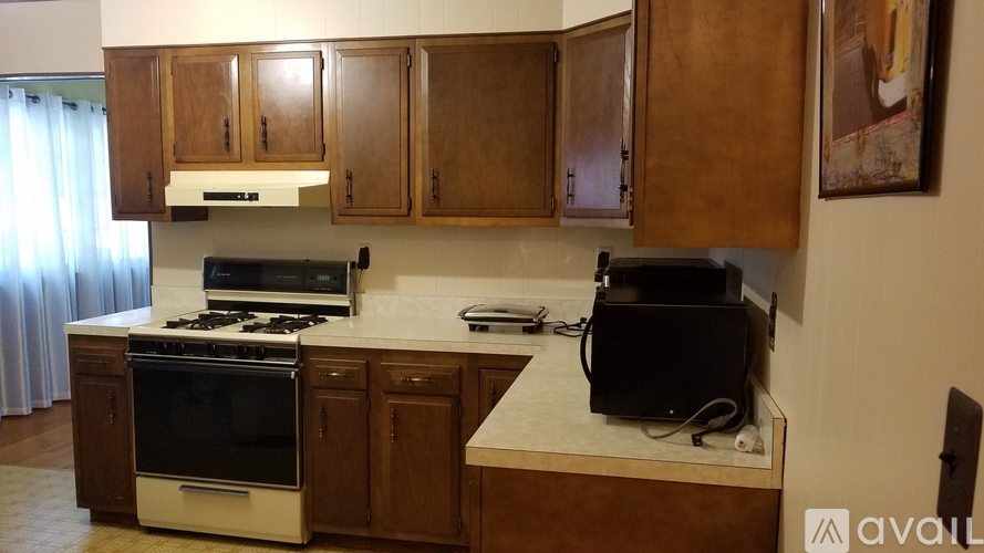 A kitchen with wooden cabinets and a black stove top oven.