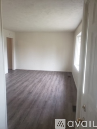 A room with wooden flooring and white walls.