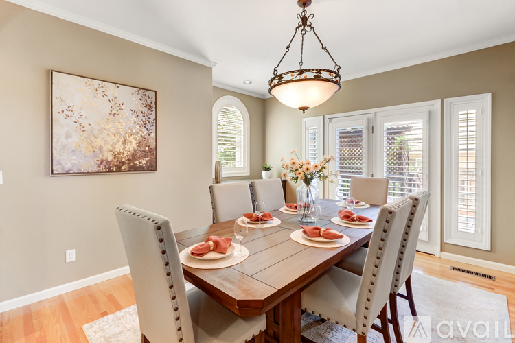 A dining room with a wooden table set for a meal.