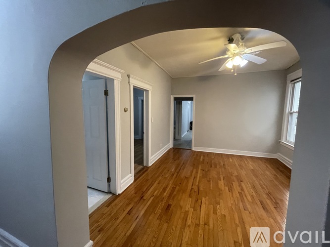 A room with wooden floors and a ceiling fan.