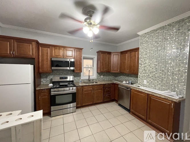 A kitchen with brown cabinets and a white refrigerator.