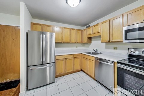 A kitchen with wooden cabinets and stainless steel appliances.