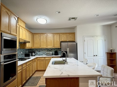 A kitchen with wooden cabinets and a marble countertop.