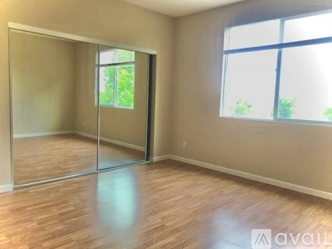 A room with a sliding glass door leading to a balcony.