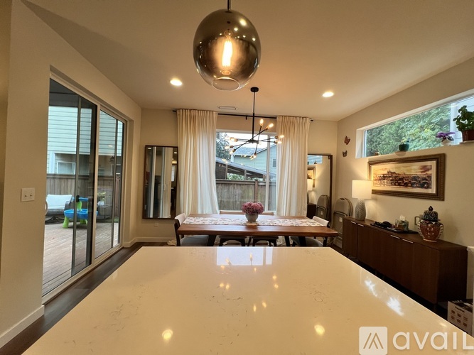 A modern dining room with a large table and a chandelier.