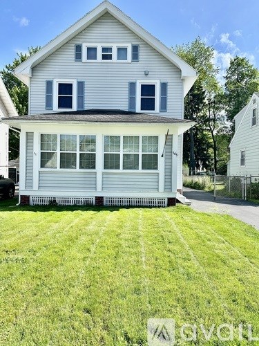 A two-story house with a grey exterior and white trim.