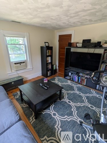 A living room with a grey sofa and a black coffee table.