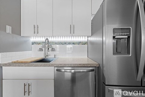 A modern kitchen with a stainless steel dishwasher and refrigerator.