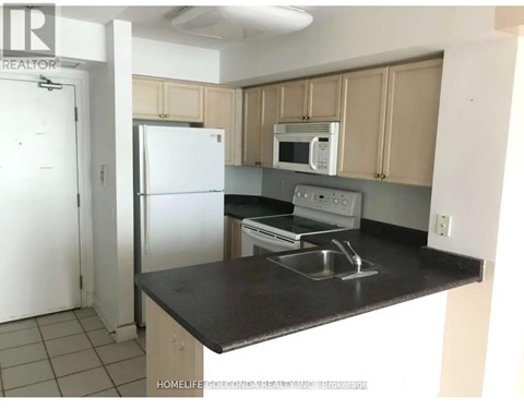 A kitchen with a black countertop and white appliances.