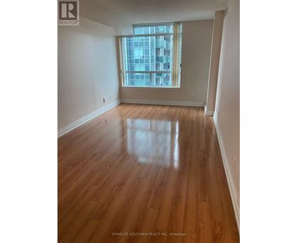 A room with wooden flooring and a large window.