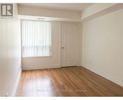 A room with a door and a window with blinds.