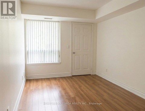 A room with a door and a window with blinds.