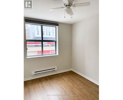 A room with a window and a fan.