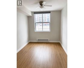 A room with a window and a fan on the ceiling.