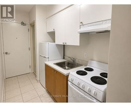 A kitchen with white appliances and cabinets.