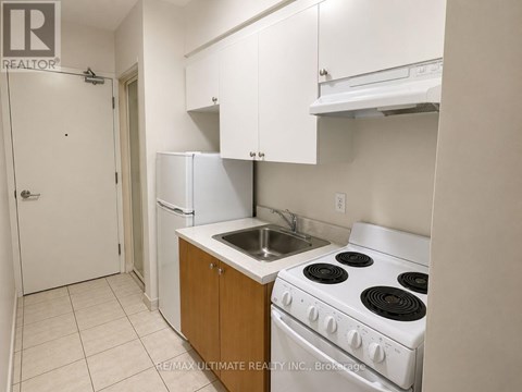 A kitchen with white appliances and cabinets.