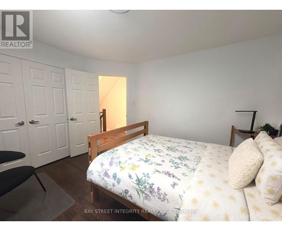 A bedroom with a bed, chair, and wardrobe.