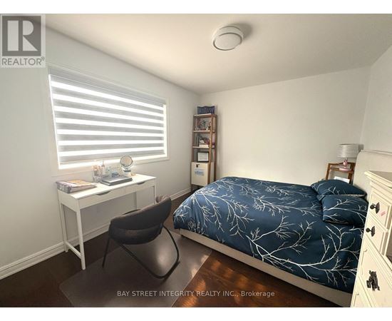A bedroom with a bed, desk, and chair.