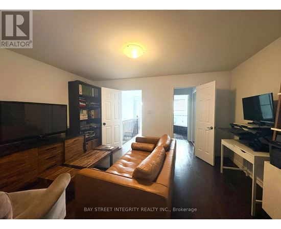 A living room with a brown leather couch and a flat screen TV.