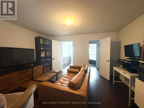 A living room with a brown leather couch and a flat screen TV.