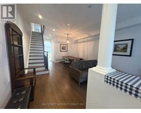 A spacious living room with a staircase and a couch.