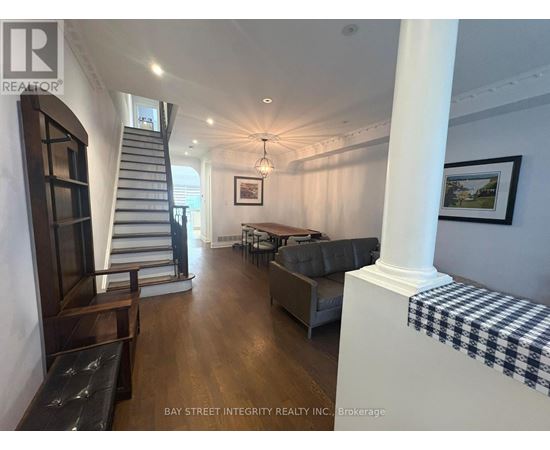 A spacious living room with a staircase and a couch.